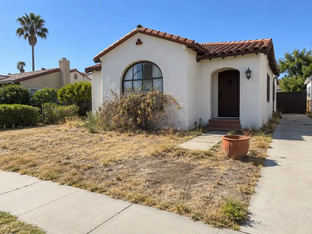 Before: the dead brown lawn and dying shrub in front of a Spanish-style California home on a sunny morning
